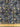 Close-up of a printed pure cotton batiste, with a geometric motif in cobalt blue, ivory, and black, with interlocking circles and angular lines, featuring a ruler at the bottom, for scale.