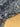 Close-up of a printed pure cotton batiste, with a geometric motif in cobalt blue, ivory, and black, with interlocking circles and angular lines, shown displayed on the table.