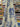 Printed pure cotton fabric with an ivory ground and blue floral motifs draped in a store setting