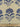 Printed pure cotton fabric with blue floral motifs on an ivory background, featuring a ruler at the bottom for scale.
