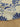 Close-up of a printed pure cotton fabric with large blue floral motifs and ivory base, shown draped on a shop table.