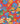 A close-up of Liberty Fabrics floral pattern featuring blue, yellow, and purple flowers with green leaves on a bright red background.