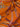 Close-up of a printed pure wool fabric with intertwined ropes, tassels, and chains on a vivid orange ground