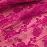 Close-up of pink organza fabric with 3D floral embroidery