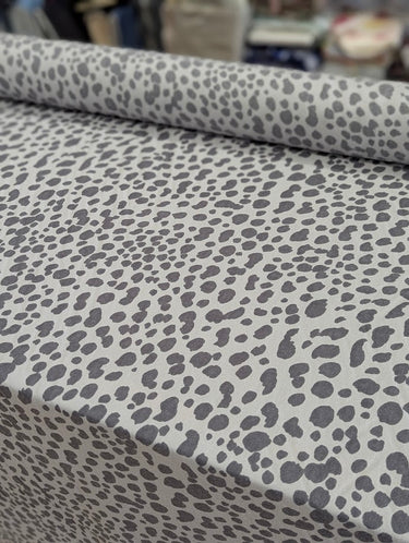 Grey leopard pattern printed on 100% wool fabric displayed on a table