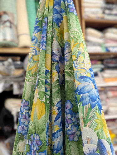 Tropical floral fabric with blue, green, and yellow colors in a store setting.