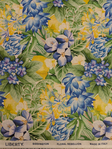 Floral fabric pattern with blue, yellow, and green colors on a Liberty of London label.