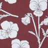 A close-up of Liberty Fabrics floral fabric featuring white pansy flowers and stems printed on a deep burgundy background.