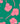 A close-up of Liberty Fabrics floral pattern featuring pink flowers and stems on a vibrant green background.
