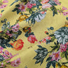 Close up of floral patterned fabric with colourful flowers and leaves on a yellow background