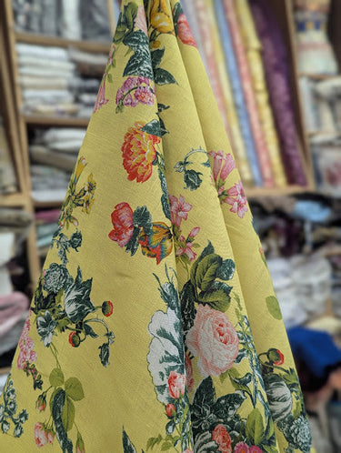 Floral patterned fabric with a yellow background draped in a store setting