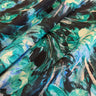 Close-up of a pure wool fabric with painterly florals in green, black, and blue.