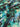 Close-up of a pure wool fabric with painterly florals in green, black, and blue.