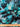Pure wool fabric with abstract painterly florals in green, black and blue shown with a ruler at the bottom for scale.