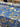 A bolt of linen fabric with a floral pattern on a blue background shown in a shop setting