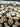 A bolt of printed pure wool fabric featuring yellow flowers on a navy background, unrolled on a table.