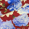 Close-up of a pure wool fabric with blue and white flowers on a red background