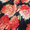 Close-up of printed pure wool fabric with pink and red flowers on a dark navy background
