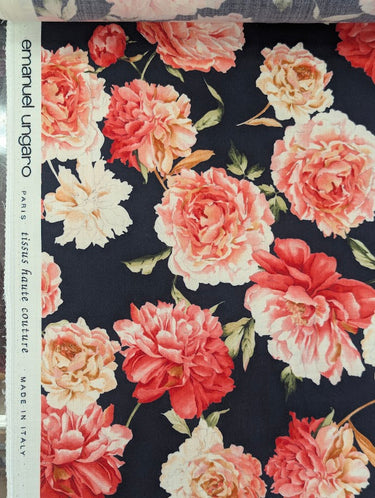 Floral fabric with pink and red flowers on a dark navy background, featuring the brand 'Emanuel Ungaro' on the selvedge.