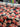 Roll of printed pure wool fabric with pink and red flowers on a dark navy background, shown on a shop table.