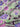 A linen fabric with a bold floral print featuring primarily blue, pink and grey colours on a green background.